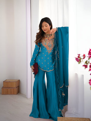 Girl Wearing turquoise-blue Ananya Shimmer Silk Palazzo Suit with Embroidery and Dupatta in her house