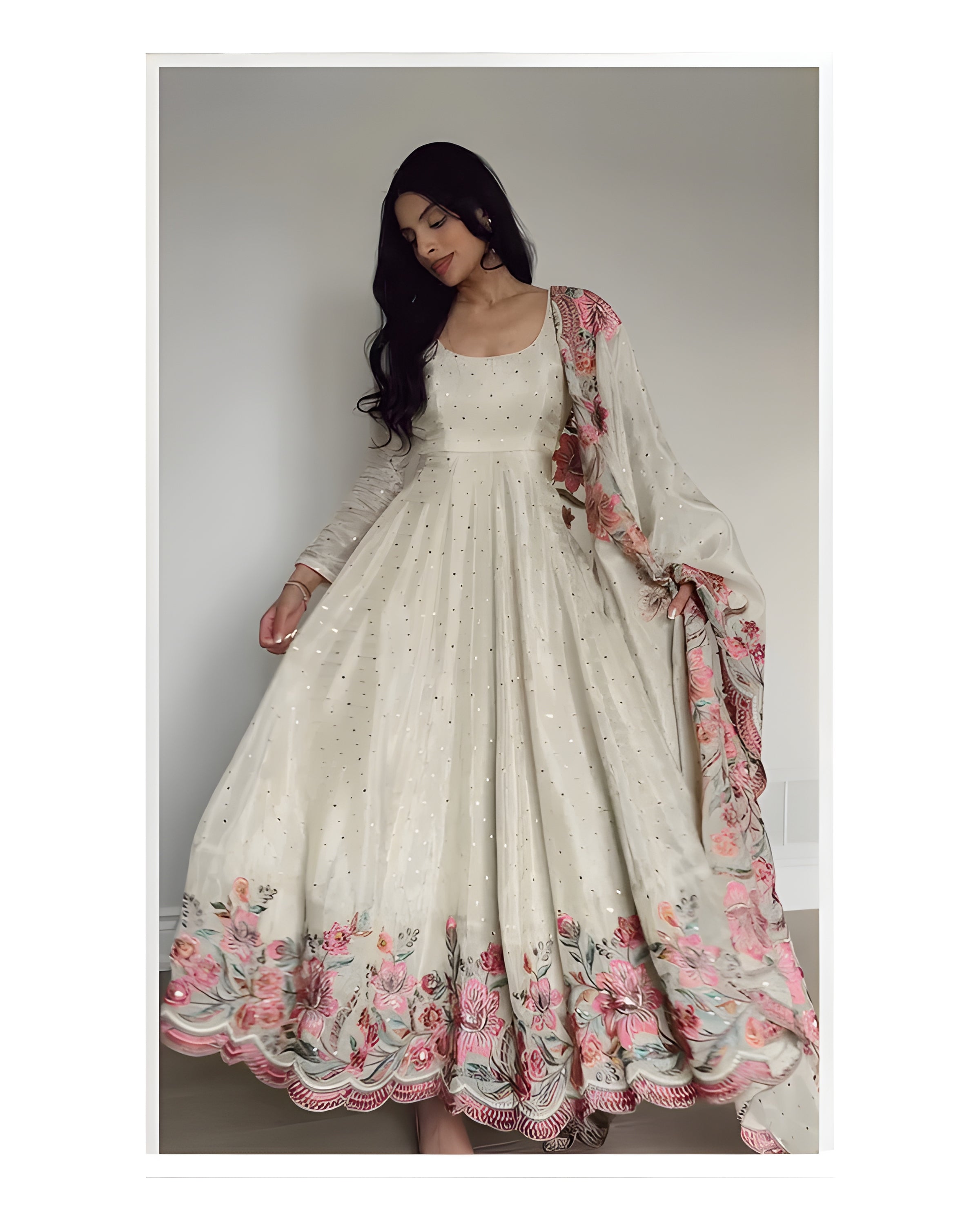 Woman wearing a white dress with floral embroidery and a matching dupatta.