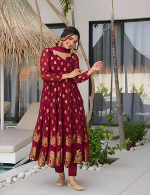 Woman in a red patterned dress standing outdoors near a poolside area.