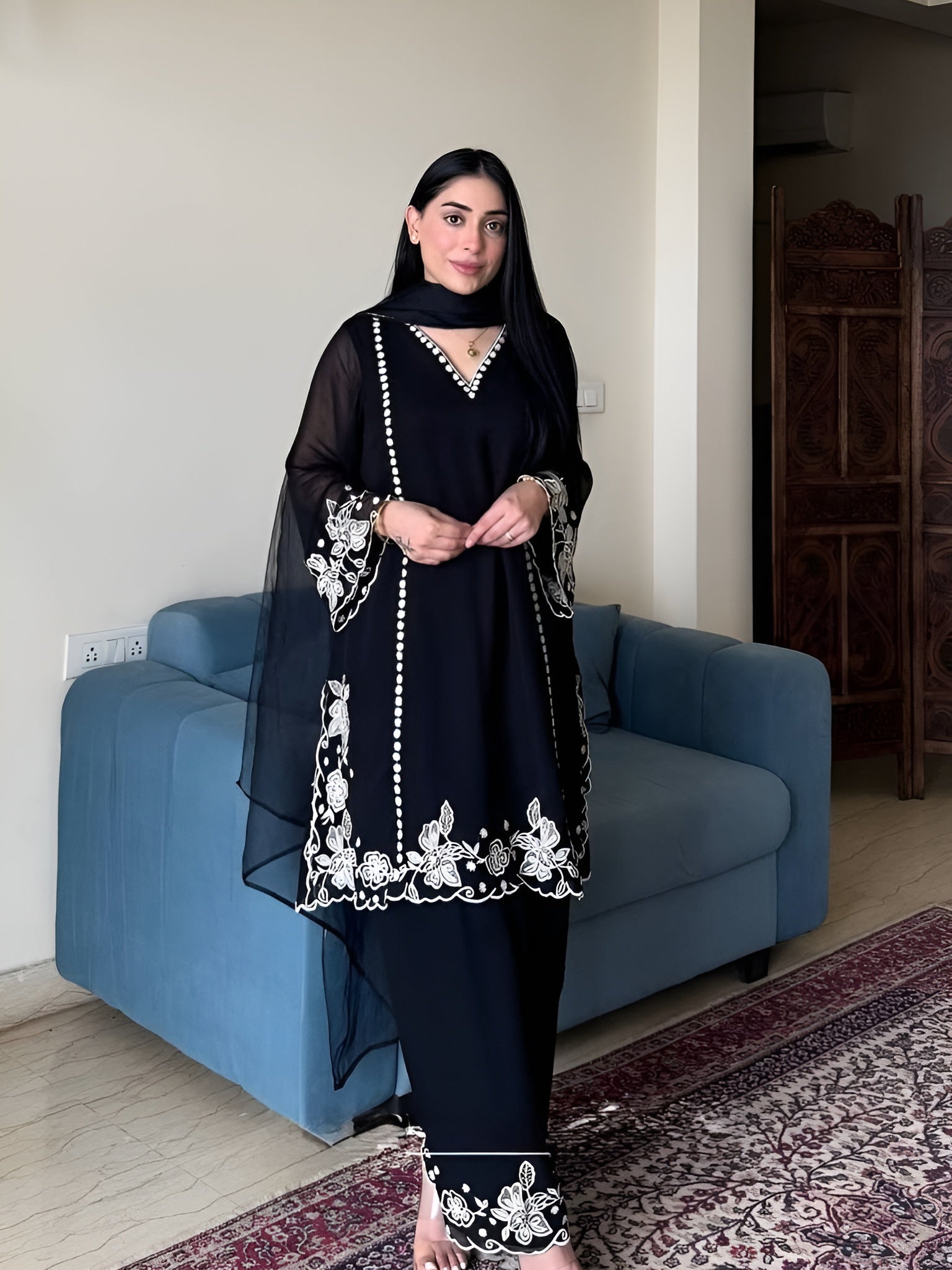 Women wearing Zoya Black Faux Georgette Embroidered Palazzo Suit with Dupatta 1-Lahariya.com standing in her house