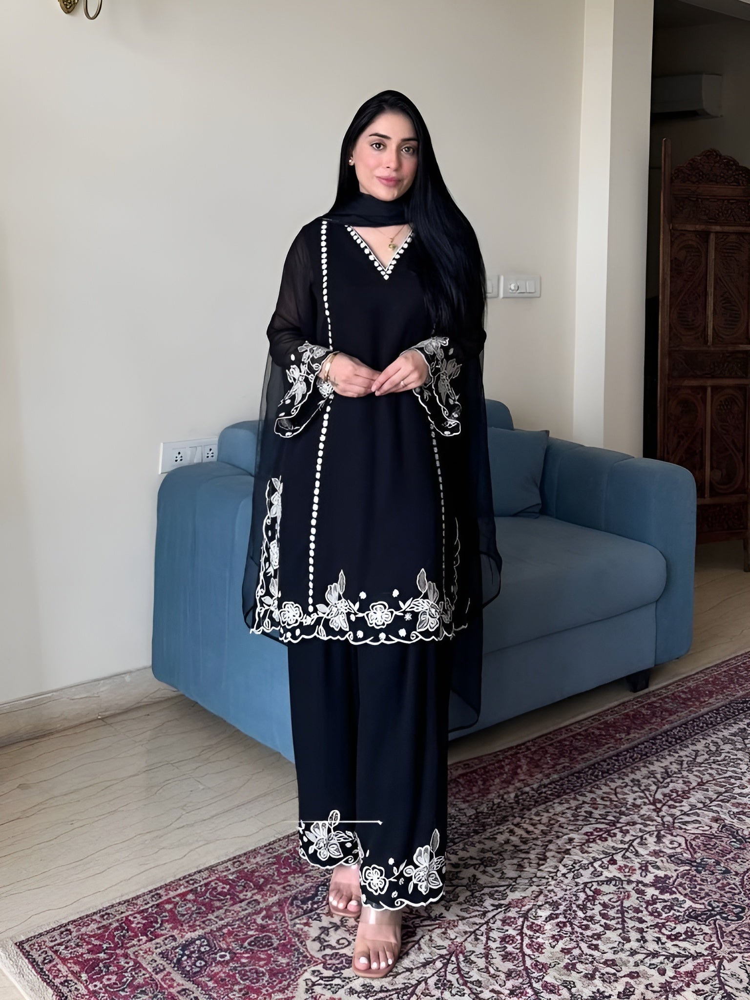 Women wearing Zoya Black Faux Georgette Embroidered Palazzo Suit with Dupatta 1-Lahariya.com standing in her house
