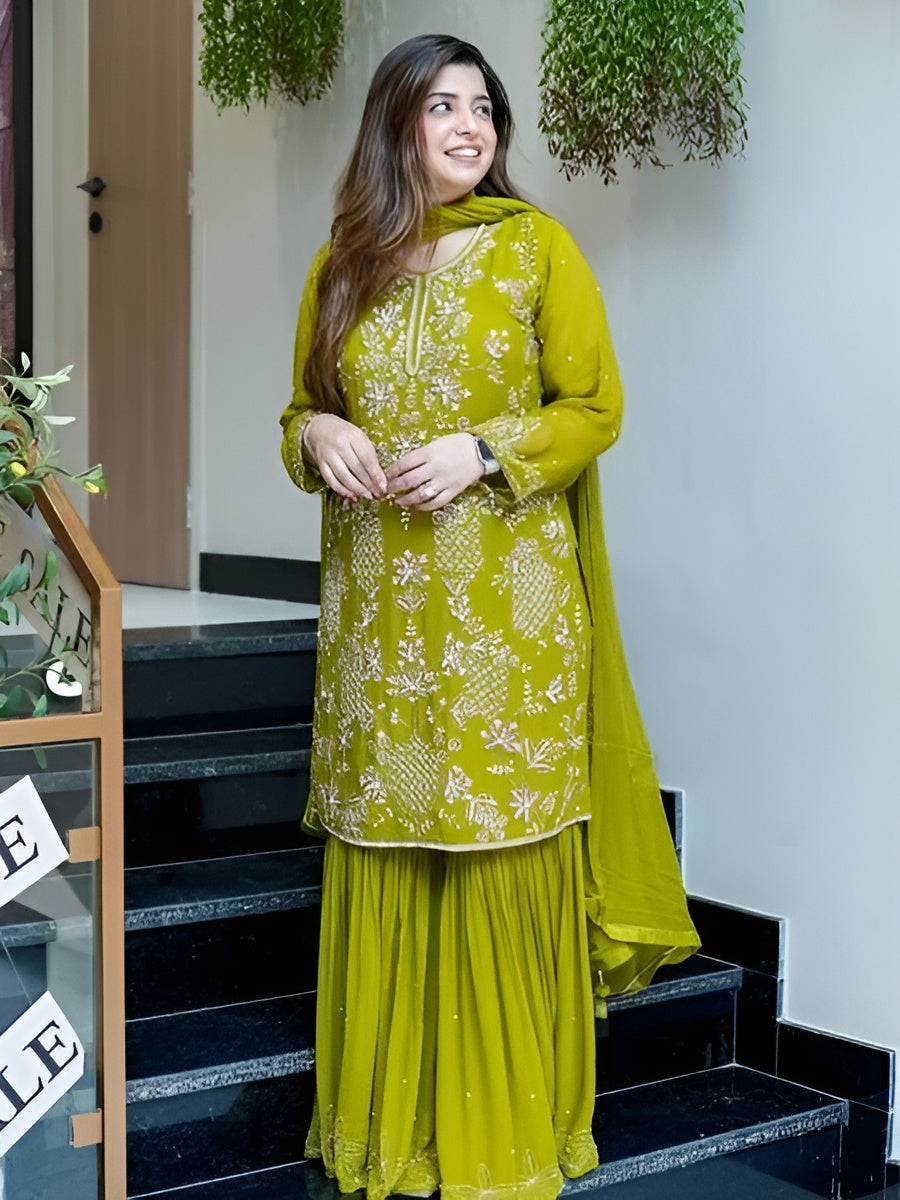 Woman in a green traditional outfit standing on a staircase.