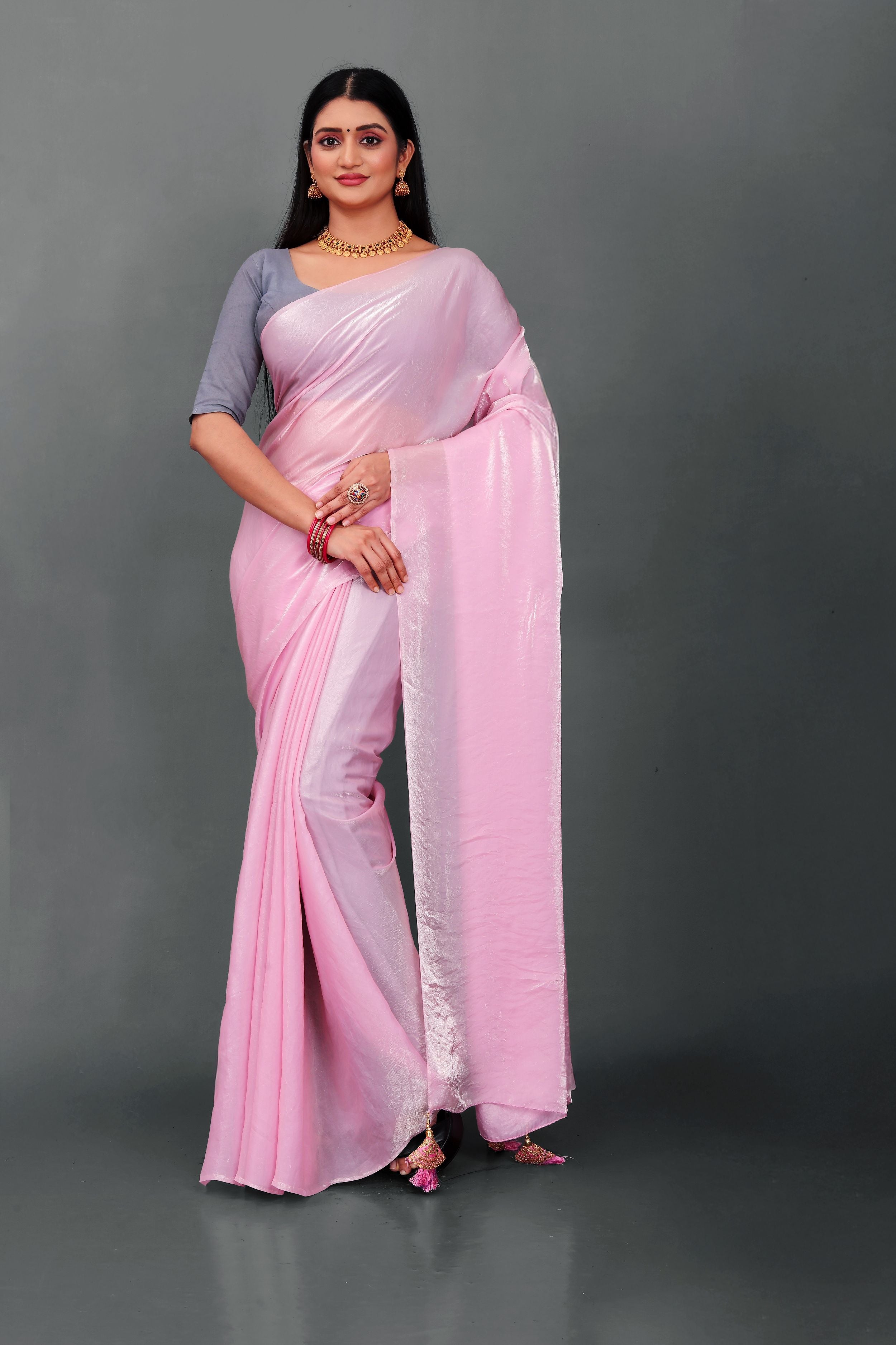 Woman wearing Lahariya “Rosé Radiance – Pink Shimmer Satin Saree” with elegant lace border and unstitched blouse – Premium festive ethnic wear from Lahariya.com