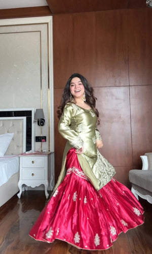 Woman in a gold and pink traditional outfit standing in a room with wooden paneling.