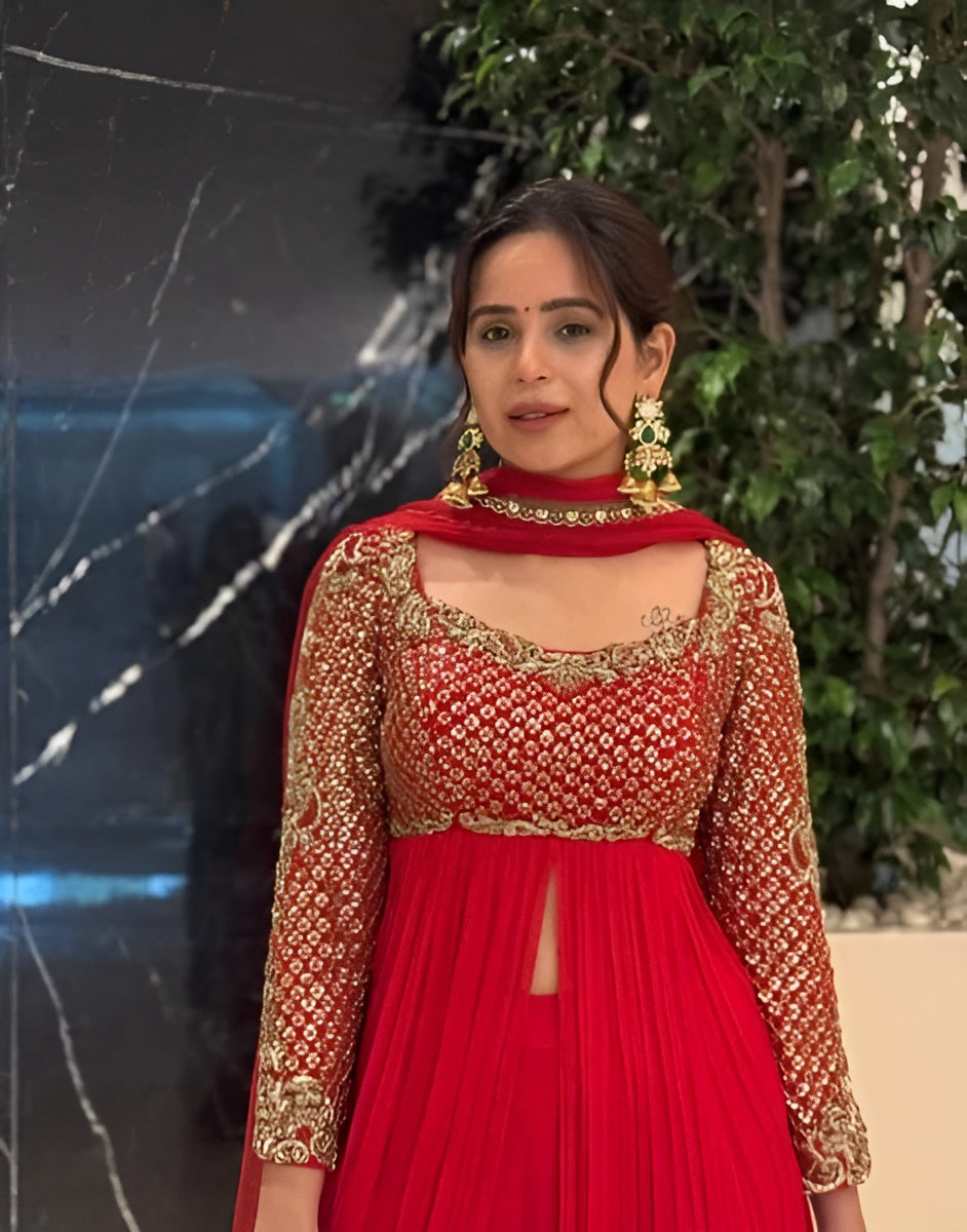 Woman wearing a red and gold traditional outfit with a blurred background