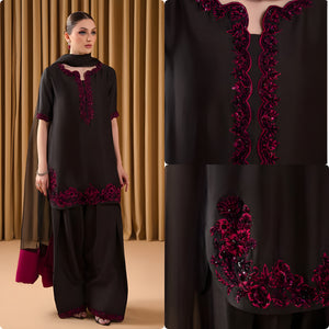 Woman wearing a black and red traditional outfit against a brown curtain background