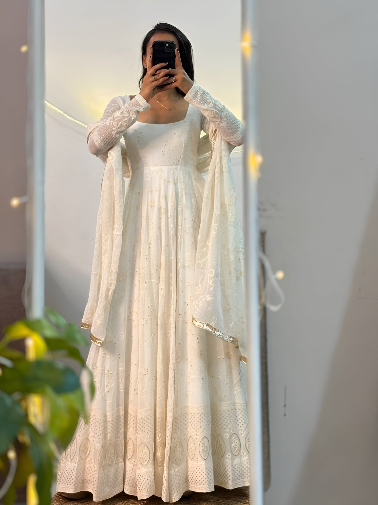 Women wearing a white lace dress standing in front of a mirror.