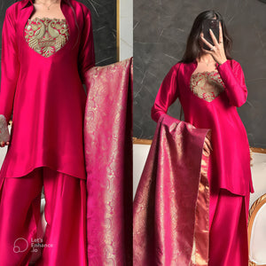 Woman wearing a pink traditional outfit with a matching dupatta, posing in front of a mirror.