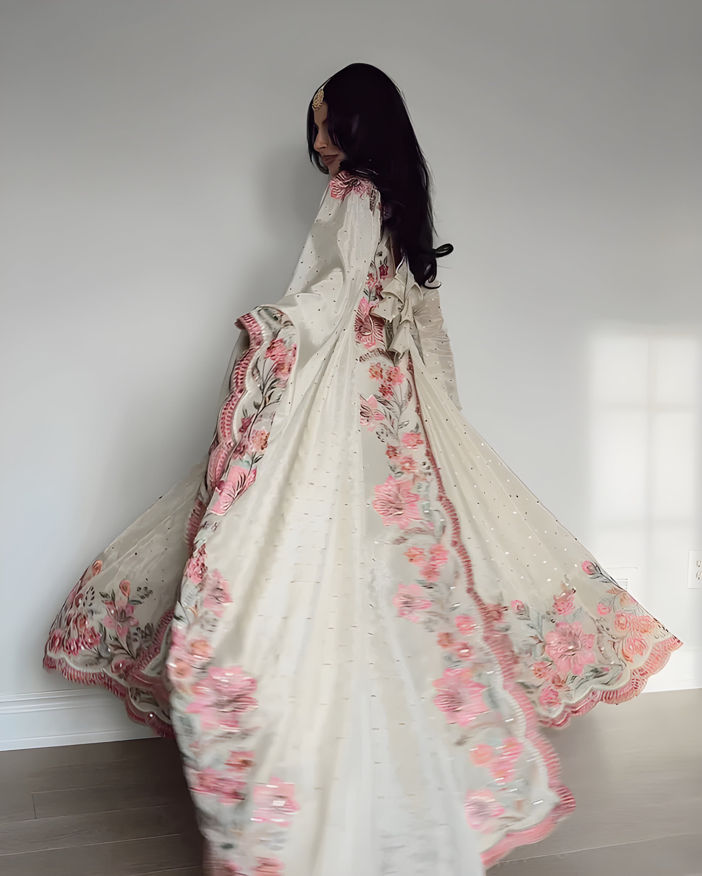 Woman holding a floral embroidered fabric against a white wall