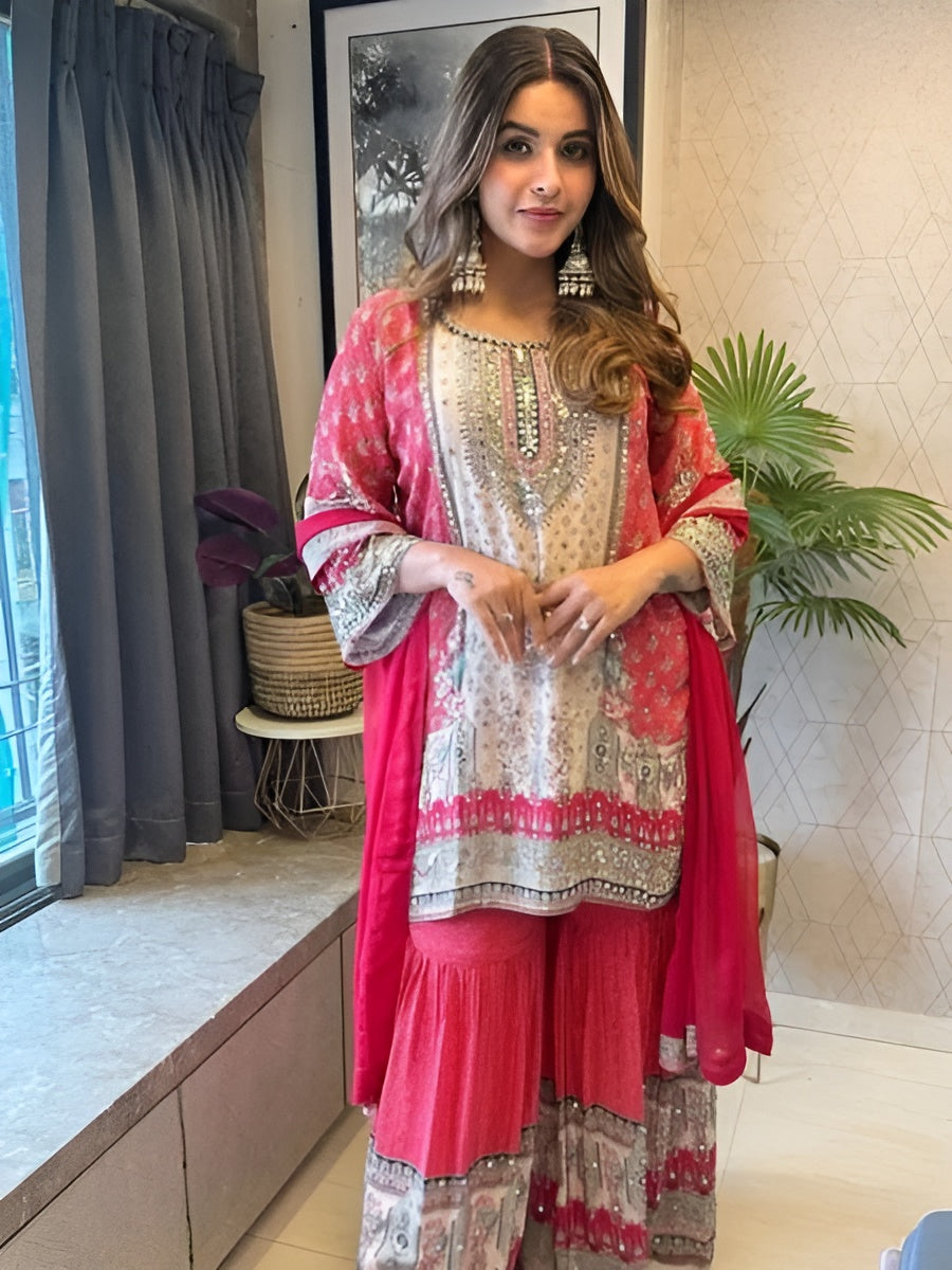 Woman in a red and white traditional outfit standing indoors with decor elements.