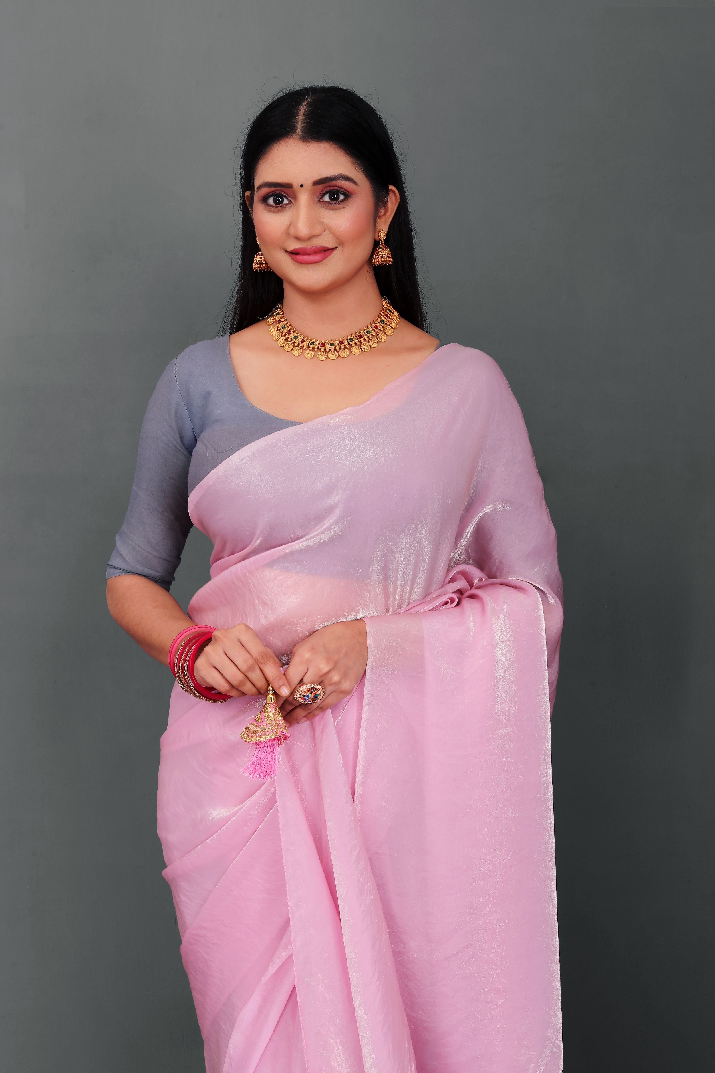 Woman wearing Lahariya “Rosé Radiance – Pink Shimmer Satin Saree” with elegant lace border and unstitched blouse – Premium festive ethnic wear from Lahariya.com