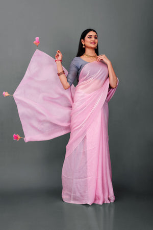Woman wearing Lahariya “Rosé Radiance – Pink Shimmer Satin Saree” with elegant lace border and unstitched blouse – Premium festive ethnic wear from Lahariya.com