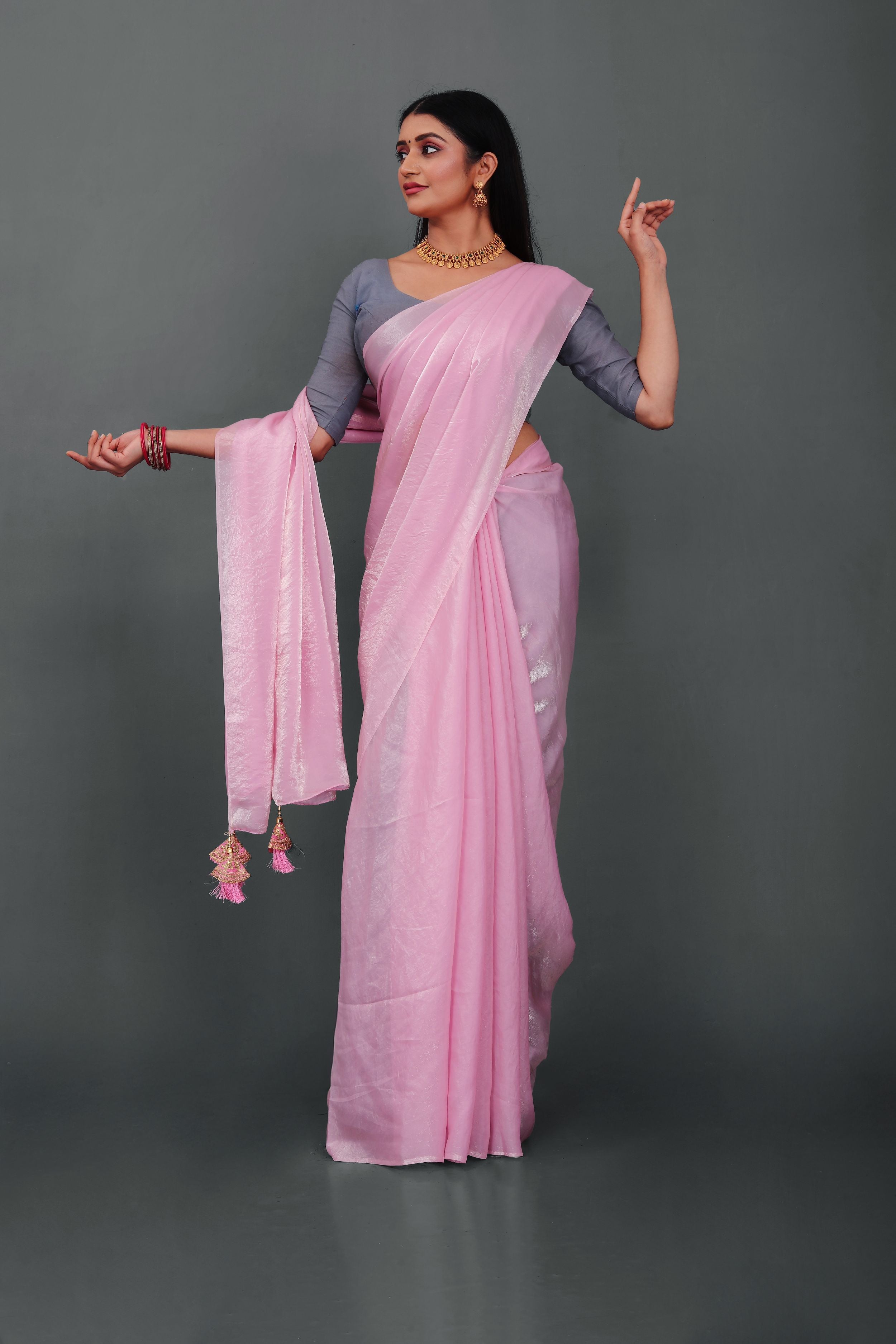 Woman wearing Lahariya “Rosé Radiance – Pink Shimmer Satin Saree” with elegant lace border and unstitched blouse – Premium festive ethnic wear from Lahariya.com
