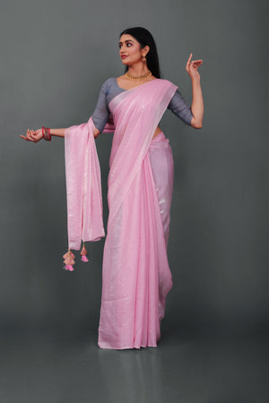 Woman wearing Lahariya “Rosé Radiance – Pink Shimmer Satin Saree” with elegant lace border and unstitched blouse – Premium festive ethnic wear from Lahariya.com